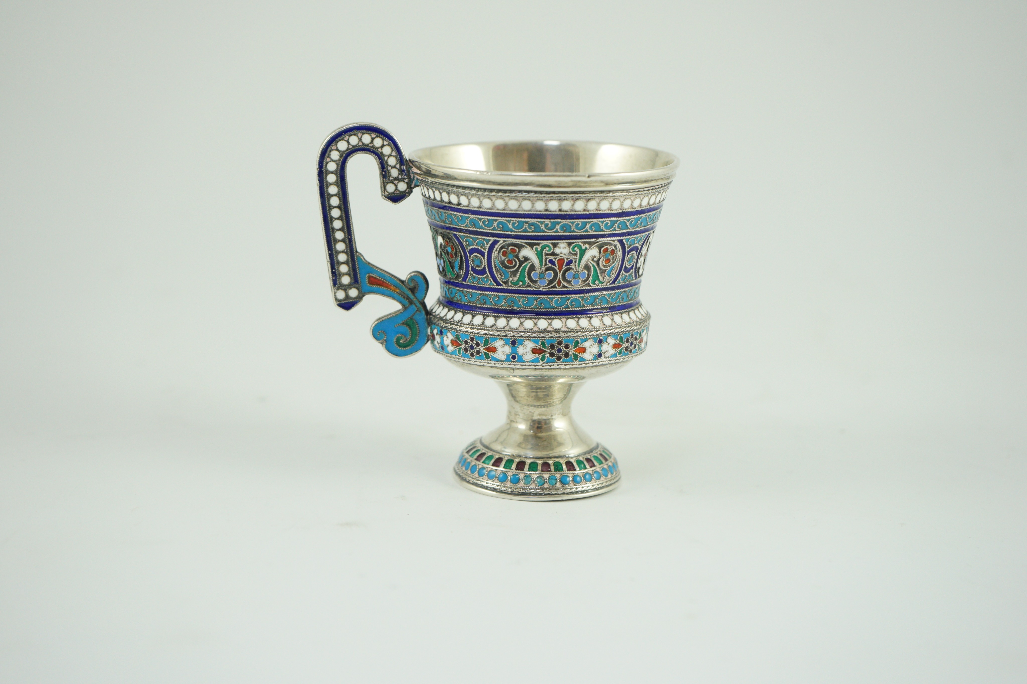 An early 20th century Russian 84 zolotnik and polychrome cloisonné enamel pedestal mug